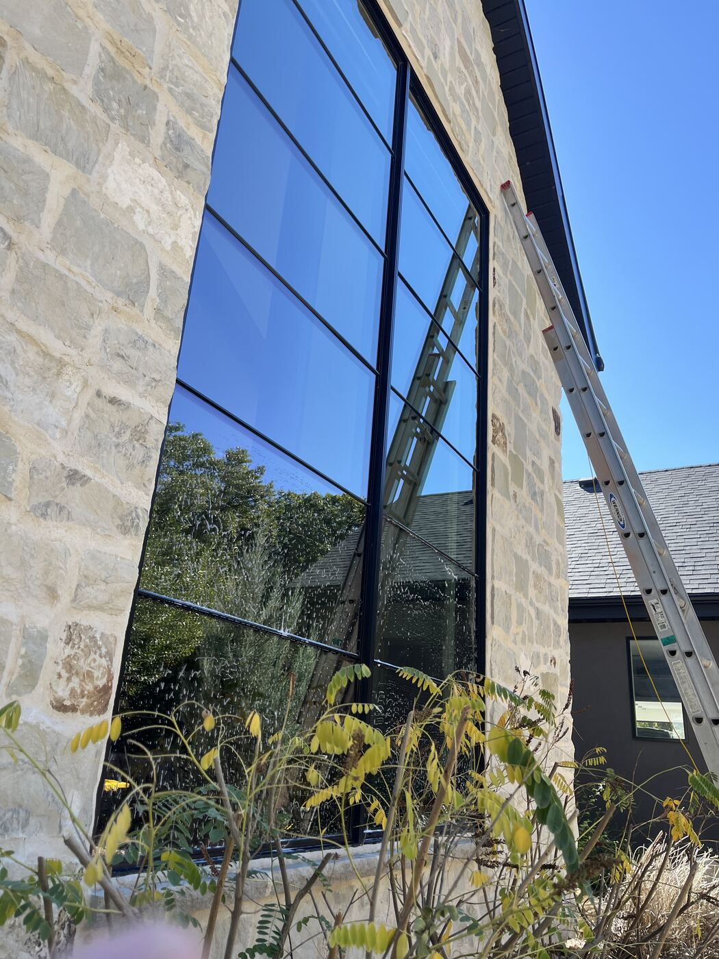 Stone house with tall black-framed glass